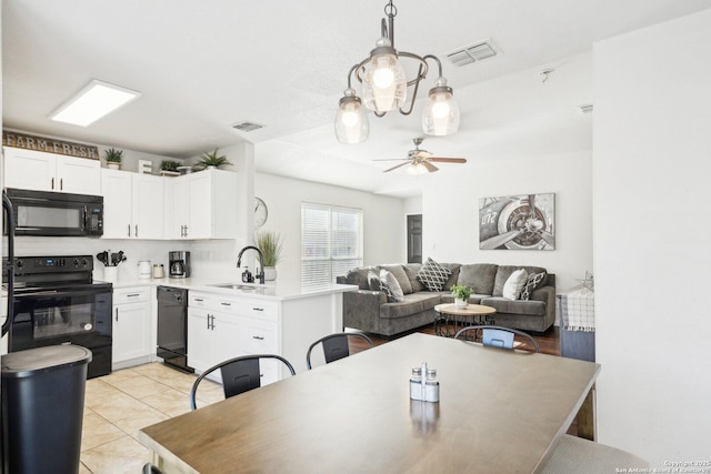 tiled dining area featuring sink and ceiling fan with notable chandelier