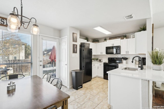 kitchen with pendant lighting, black appliances, sink, white cabinetry, and kitchen peninsula