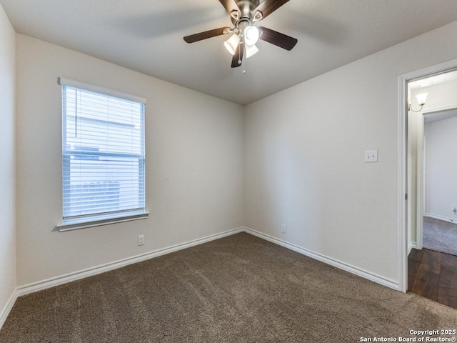 empty room featuring ceiling fan and dark carpet