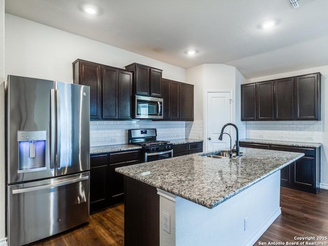 kitchen featuring a center island with sink, sink, dark hardwood / wood-style floors, appliances with stainless steel finishes, and dark brown cabinetry