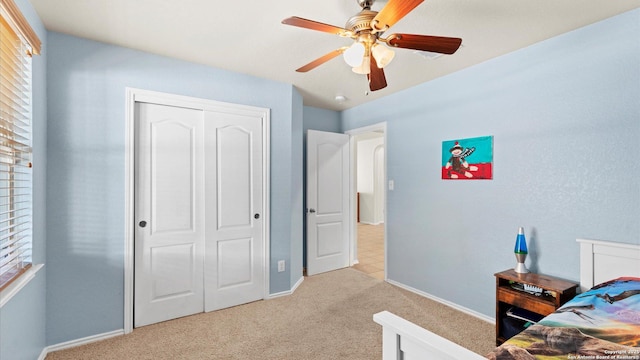 carpeted bedroom with a closet and ceiling fan