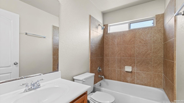 full bathroom with vanity, tiled shower / bath combo, and toilet