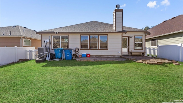 rear view of house featuring a yard and central AC unit