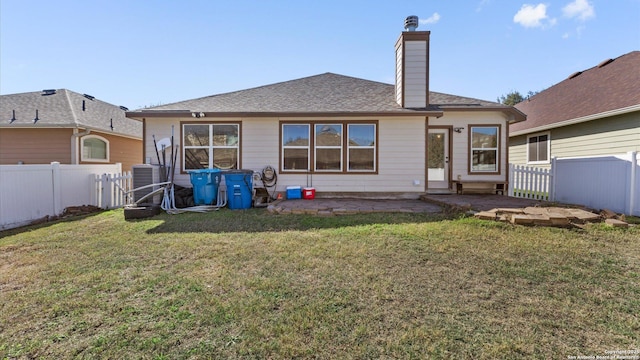 back of property featuring a yard and central AC