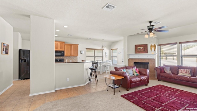 living room featuring ceiling fan, light tile patterned floors, and a fireplace