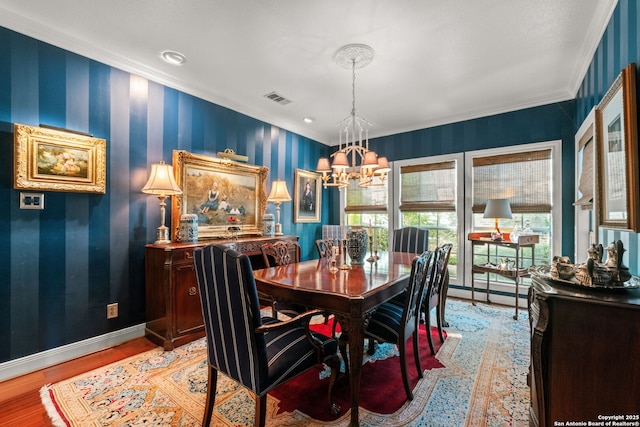 dining room with light hardwood / wood-style flooring, crown molding, and a chandelier