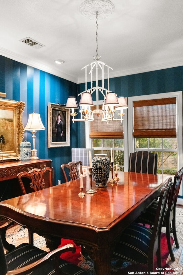 dining space featuring ornamental molding and a notable chandelier