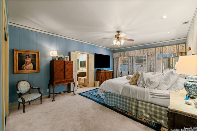 bedroom with carpet, ceiling fan, crown molding, and ensuite bathroom