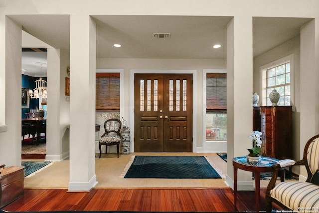 foyer featuring wood-type flooring and an inviting chandelier