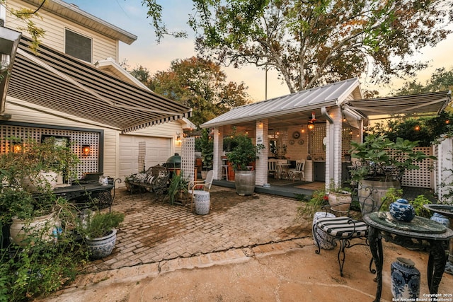 patio terrace at dusk featuring a garage and a wooden deck