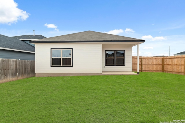 rear view of property featuring a lawn