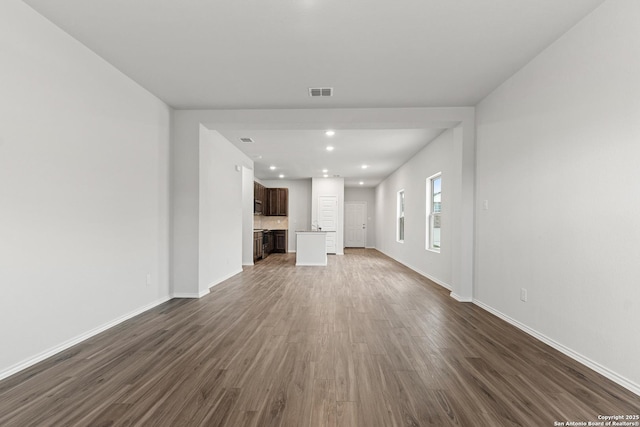 unfurnished living room with dark wood-type flooring