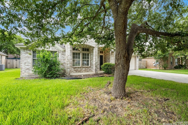 view of front facade with central air condition unit, a front yard, and a garage