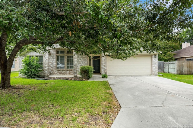 obstructed view of property with a garage and a front lawn