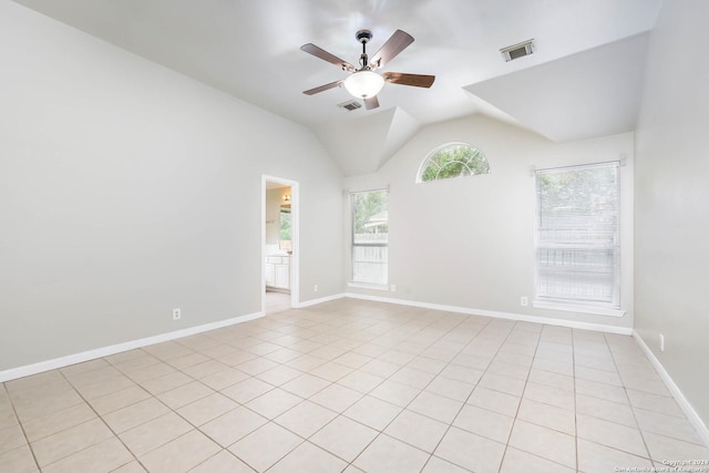 tiled empty room with ceiling fan and vaulted ceiling