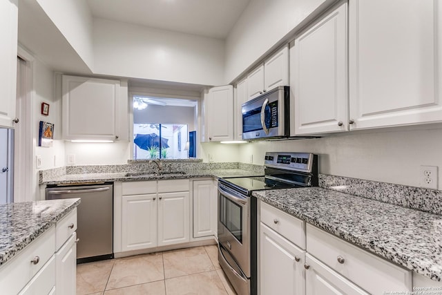 kitchen featuring light stone countertops, ceiling fan, sink, stainless steel appliances, and white cabinets