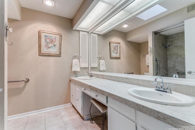 bathroom featuring tile patterned floors, a skylight, vanity, and tiled shower