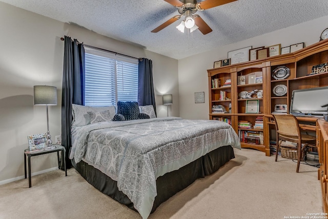 bedroom featuring ceiling fan, light colored carpet, and a textured ceiling