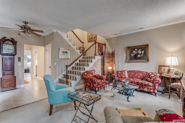 living room with tile patterned floors, ceiling fan, crown molding, and a textured ceiling