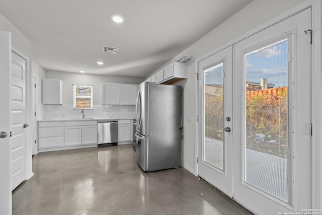 kitchen featuring decorative backsplash, sink, white cabinets, and appliances with stainless steel finishes