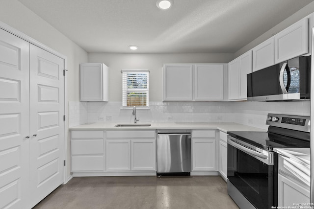 kitchen with tasteful backsplash, white cabinetry, sink, and stainless steel appliances