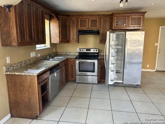 kitchen with light tile patterned floors, sink, and appliances with stainless steel finishes