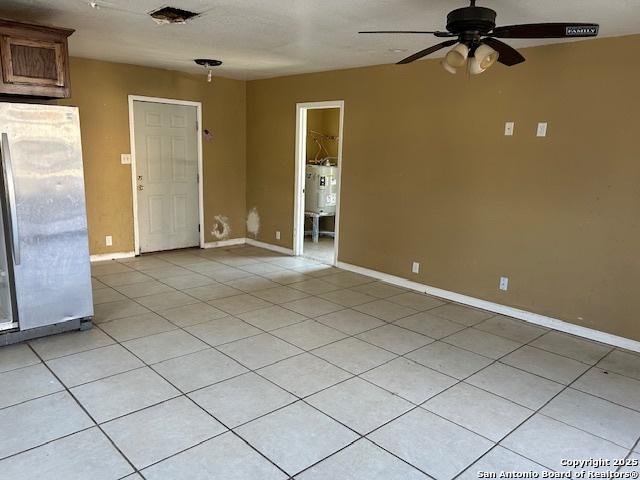 spare room with ceiling fan and light tile patterned flooring