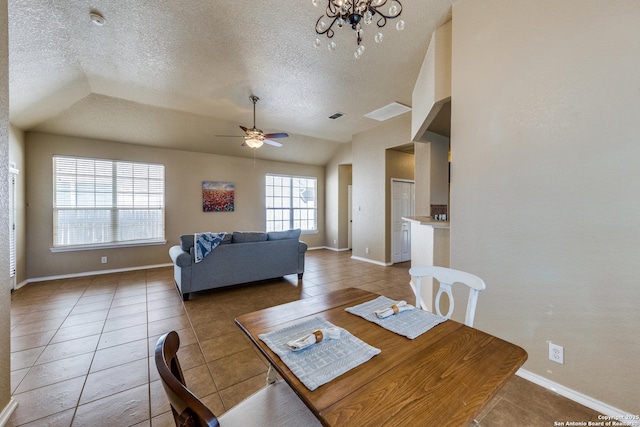 dining space featuring light tile patterned floors, baseboards, a textured ceiling, and ceiling fan with notable chandelier