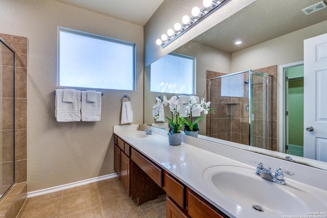 bathroom with tile patterned flooring, a stall shower, visible vents, and a sink