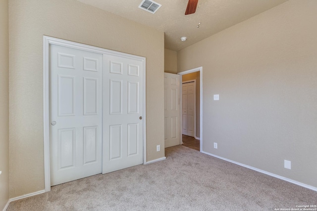 unfurnished bedroom featuring a ceiling fan, visible vents, carpet floors, baseboards, and a closet