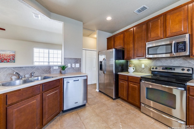 kitchen with visible vents, stainless steel appliances, light countertops, and a sink