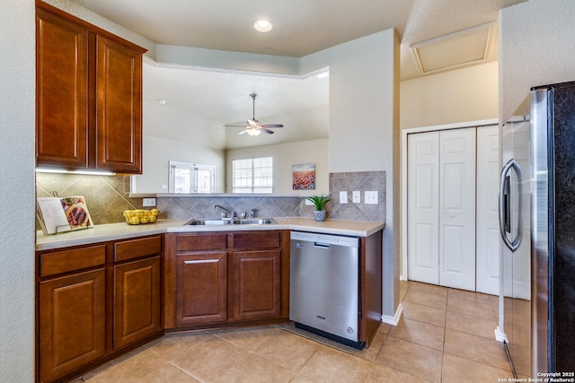 kitchen featuring tasteful backsplash, appliances with stainless steel finishes, light countertops, and a sink