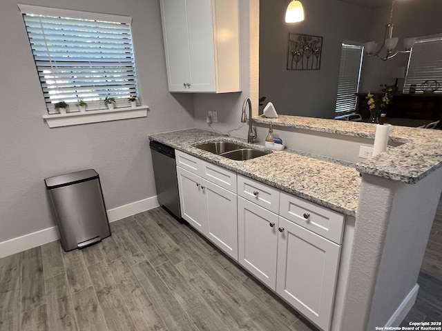 kitchen featuring kitchen peninsula, light stone countertops, sink, dishwasher, and white cabinetry