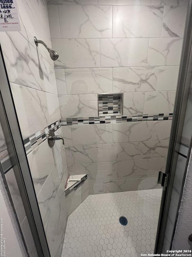 bathroom with tiled shower