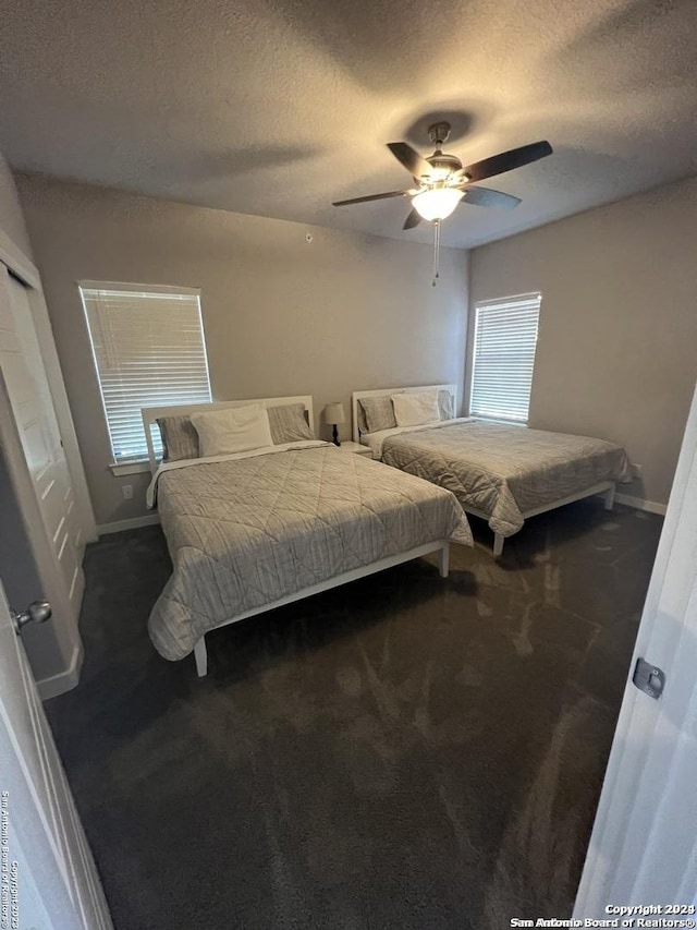 carpeted bedroom featuring a textured ceiling and ceiling fan