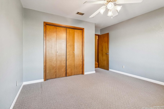 unfurnished bedroom featuring light carpet, a closet, and ceiling fan