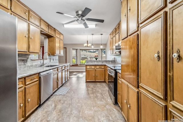 kitchen with sink, hanging light fixtures, decorative backsplash, appliances with stainless steel finishes, and kitchen peninsula