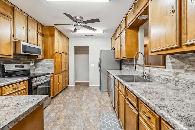 kitchen featuring backsplash, stainless steel appliances, ceiling fan, and sink