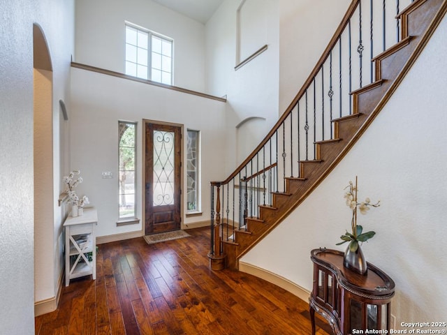 foyer entrance with dark wood-type flooring and a high ceiling