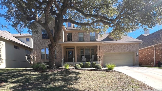 view of front of house featuring covered porch, a garage, and a front lawn