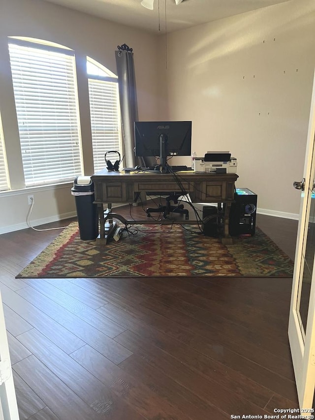 home office with ceiling fan, a wealth of natural light, and dark hardwood / wood-style flooring