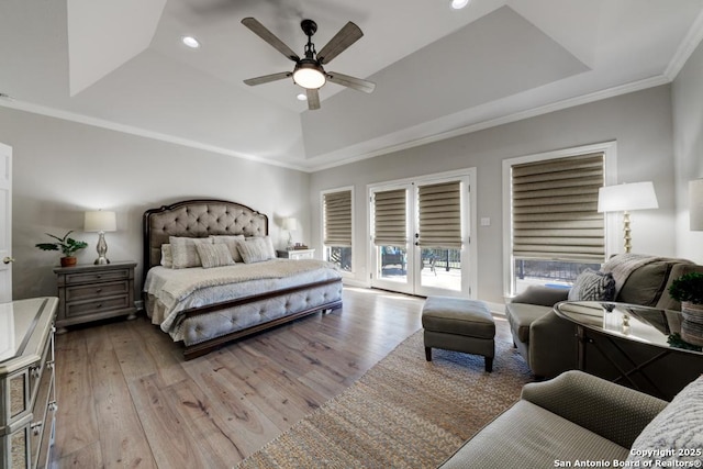 bedroom featuring ornamental molding, access to outside, ceiling fan, a tray ceiling, and light wood-type flooring