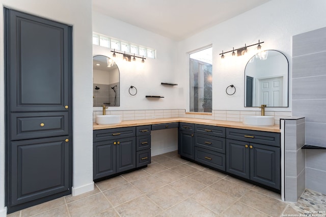 bathroom with tile patterned flooring, a shower, and vanity