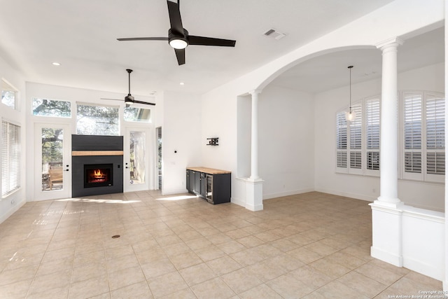 unfurnished living room with light tile patterned floors, decorative columns, and ceiling fan