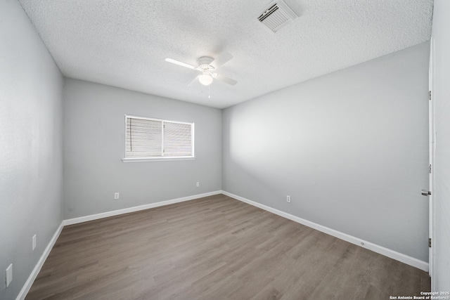 empty room with hardwood / wood-style floors, ceiling fan, and a textured ceiling