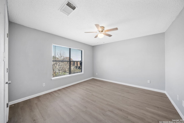 empty room featuring hardwood / wood-style floors, ceiling fan, and a textured ceiling