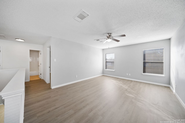 spare room with wood-type flooring, a textured ceiling, and ceiling fan