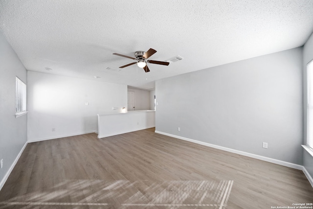 unfurnished living room with ceiling fan, light hardwood / wood-style floors, and a textured ceiling