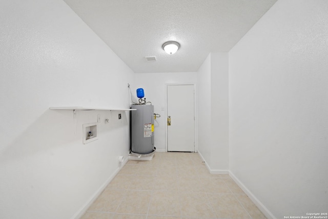 washroom featuring water heater, hookup for a washing machine, light tile patterned floors, and a textured ceiling