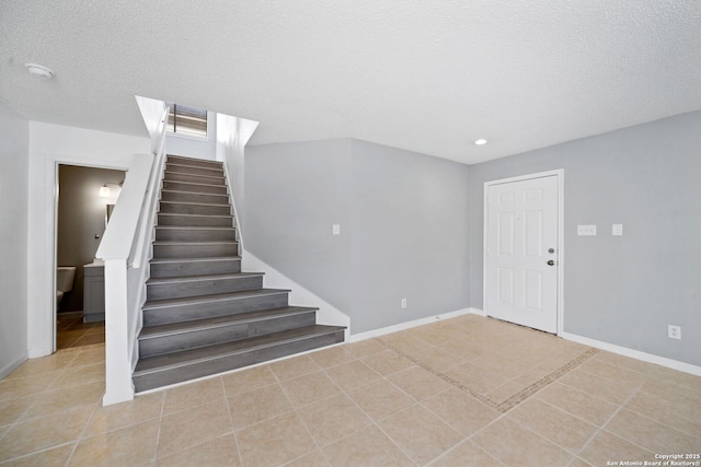 foyer featuring light tile patterned floors and a textured ceiling